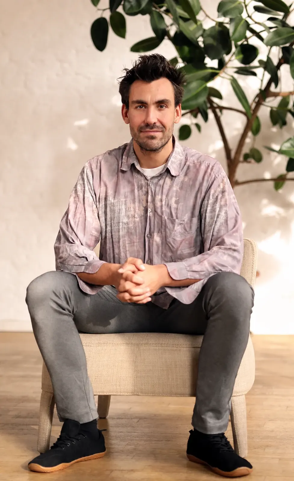 Robin Hotz sitting on a stool, smiling